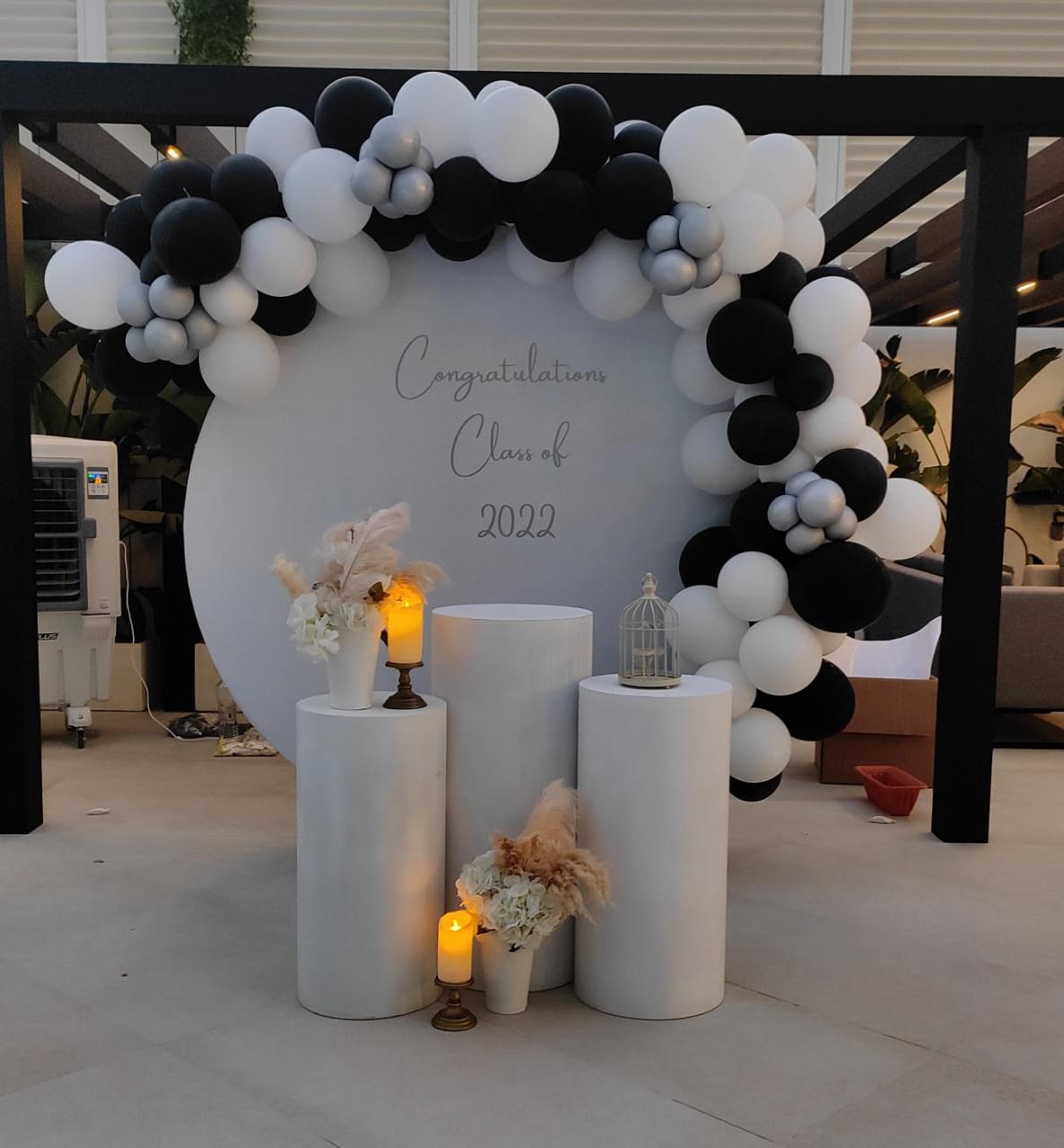 Decorative setup with balloons, candles, and flowers backdrop