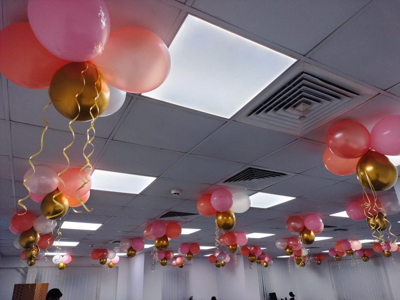Decorative balloons and streamers hanging from the ceiling in a room.