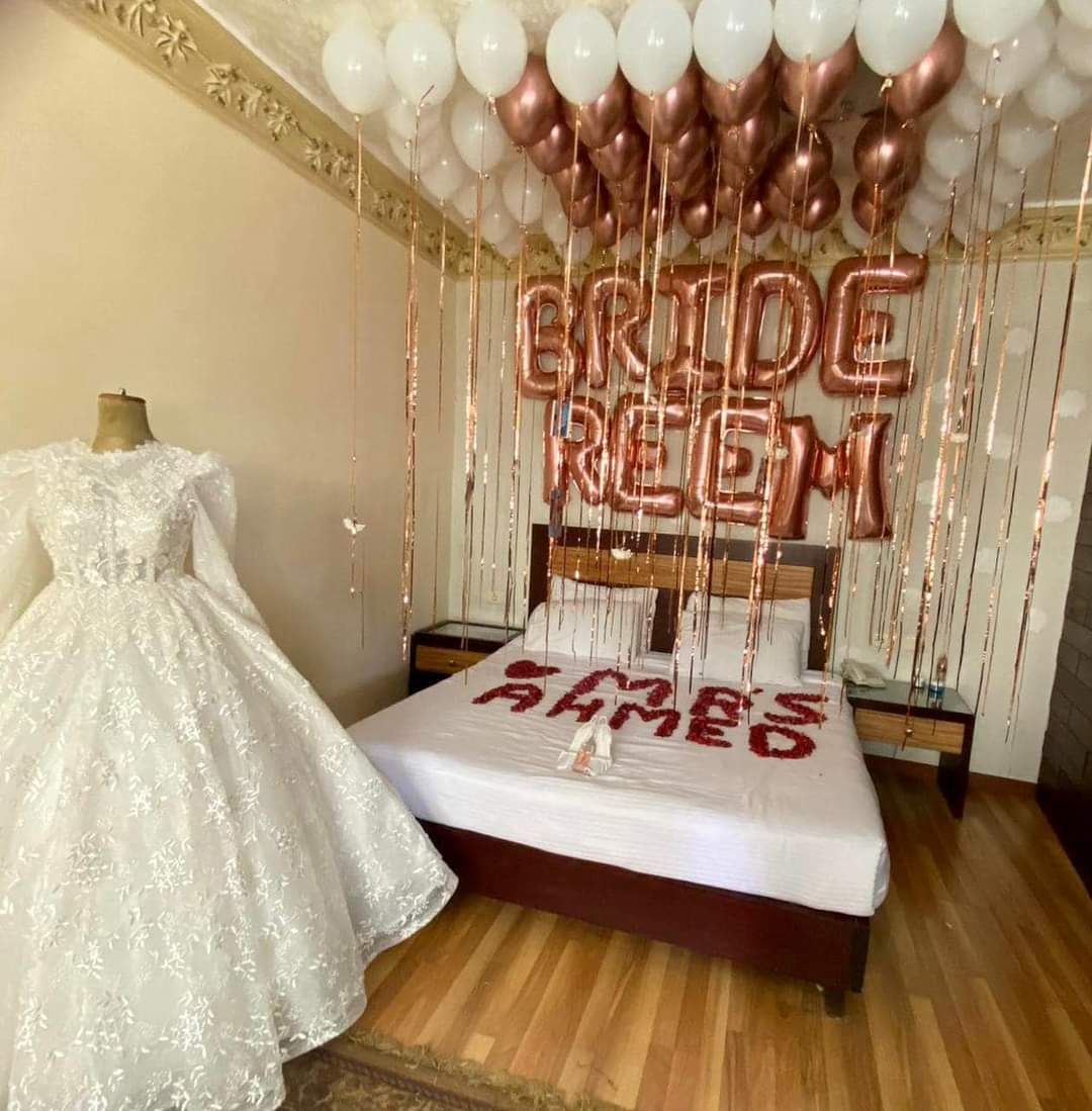 Decorated bedroom with a wedding dress, balloons, and personalized decorations.